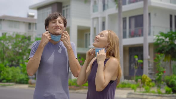 Quarantine Is Over Concept. Woman and Man Take Off Medical Masks on a Street. We Are Safe