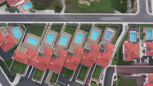 Aerial View Over Luxury Cottages with Swimming Pools and Green Lawns