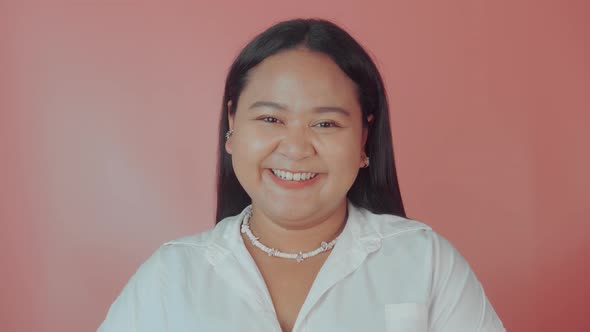 Asian Plus Size Woman in White Shirt Posing Isolated on Pink Background