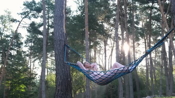 Woman Relaxing at the Forest on a Hammock