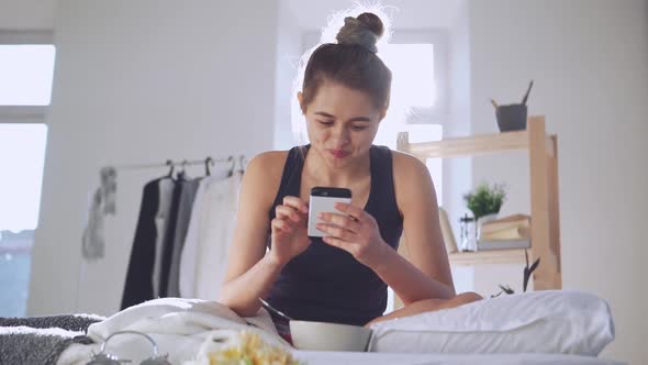 Young Woman Checking Morning News in Smartphone in Slowmotion