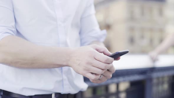 Man using smart phone, midsection