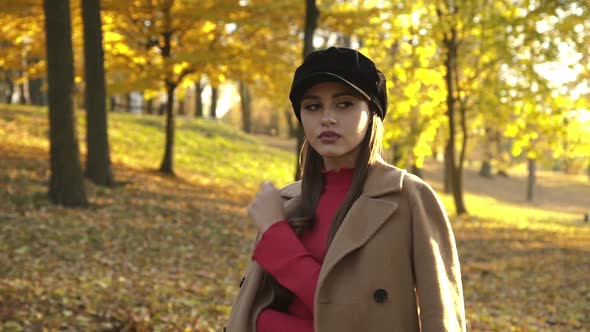 Fashion Young Girl in Stylish Clothes Posing and Flirting at Camera in Park