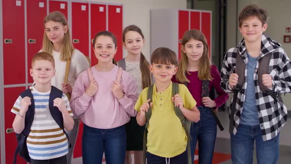 Video of group of smiling children standing in the school corridor.