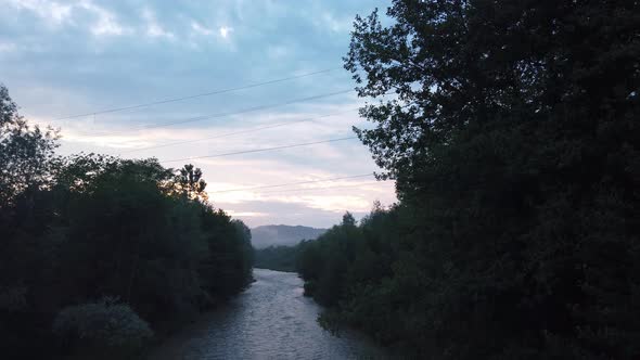 Beautiful view of the river with trees after rain fall on a cloudy summer day