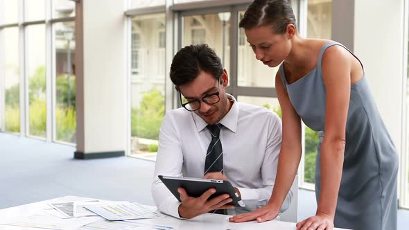 Business executives discussing over digital tablet 