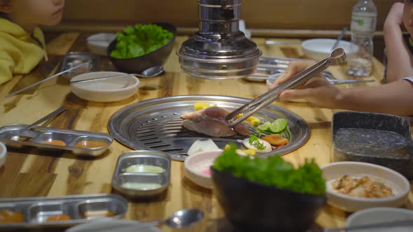 Family Visits a Korean Grill Restaurant Where You Can Cook Your Own Food. Travel To Korea Concept