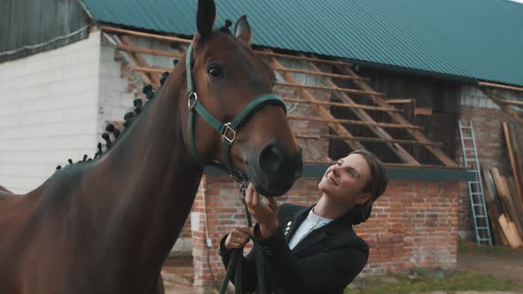 Female Horse Owner Touching A Seal Brown Horse With Love Outside The Horse Stable