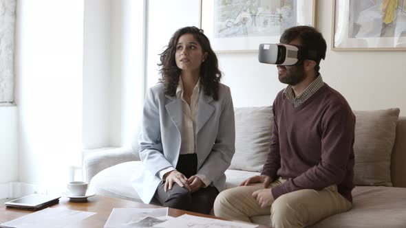 Caucasian Man Wearing Virtual Reality Headset and Talking with Interior Design