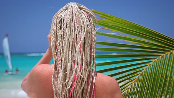 Woman with African Braids in Pink Bikini on Tropical Beach with Turquoise Sea Water