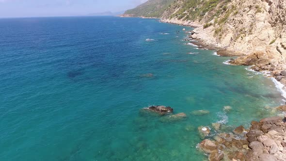 Aerial Clear Reef and Rocky Untouched Coastline of Bright Turquoise Sea