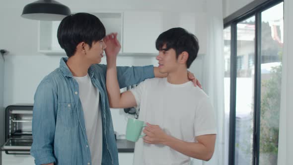 Asian gay couple drinking coffee, having a great time at home