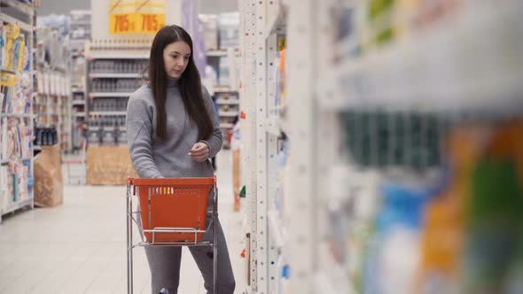 Young Women Selecting Liquid Soap for House at Supermarket