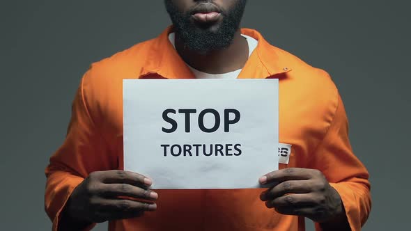 Stop Tortures Phrase on Cardboard in Hands of Afro-American Prisoner, Assault