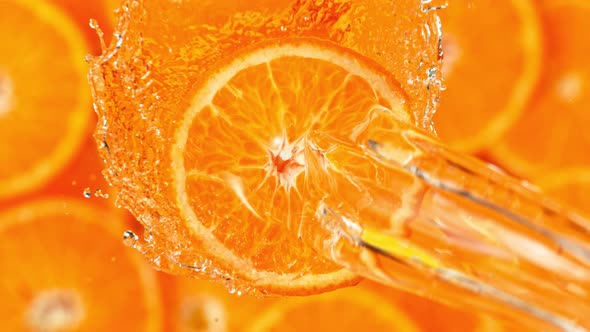 Super Slow Motion Shot of Splashing Water on Rotating Orange Slice at 1000Fps