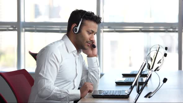 Call Center Worker Smiling Against Huge Windows.