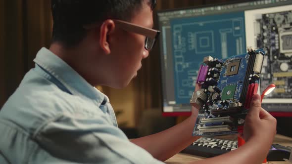 Asian Boy Is Working With Desktop Computer And Looking At Mainboard In Home