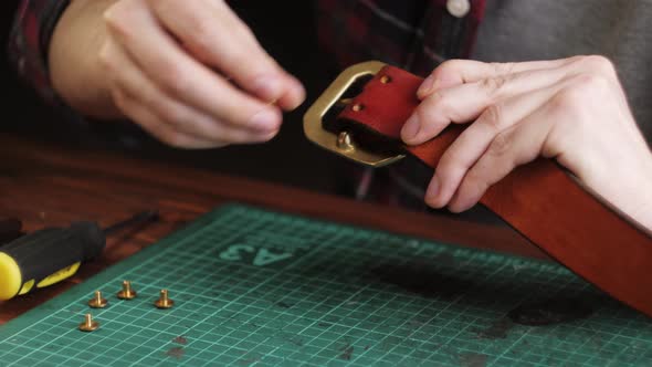 Man Tailor Cutting Artificial Leather with Ruler Closeup