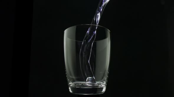 Purple water pouring into glass, Slow Motion