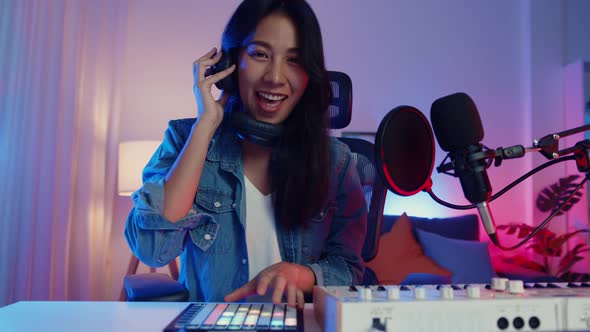 asia girl dj play launchpad synthesizer keyboard sound mixer wear headphone and performance music.