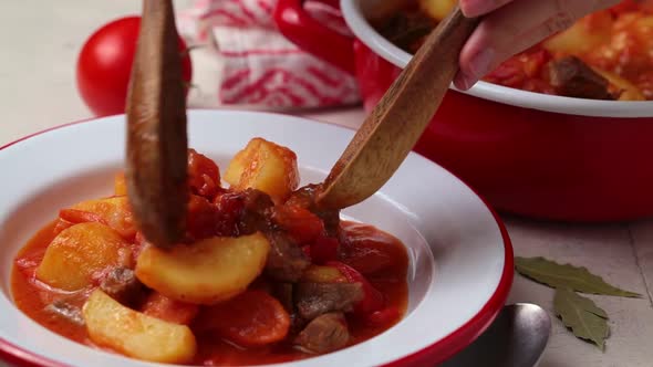 Beef Stew with Potatoes and Carrots in Tomato Sauce in White Plate