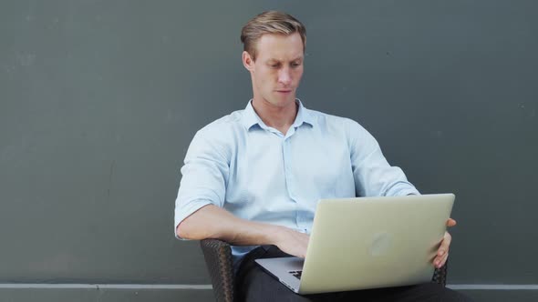Handsome Guy with Fair Hair Opens Modern White Laptop