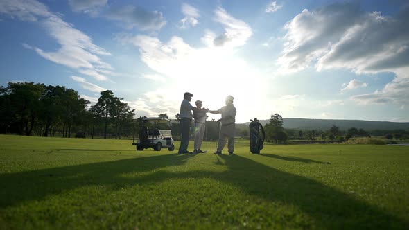 4K Group of Asian men golfer shaking hand after finish the game on golf course at summer sunset