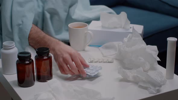 Close Up of Hand Searching for Capsule Tablets Against Virus