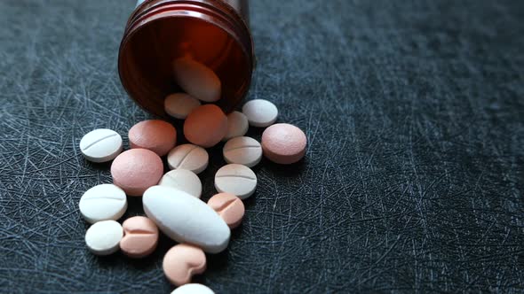 Close Up of White Pills Spilling on Black Background 