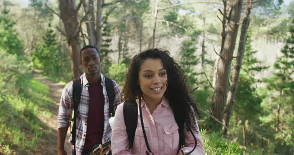 Smiling diverse couple taking photo and hiking in countryside