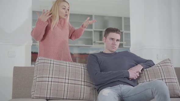 Young Blond Caucasian Woman Complaining Husband About Her Life, Man Ignoring His Spouse