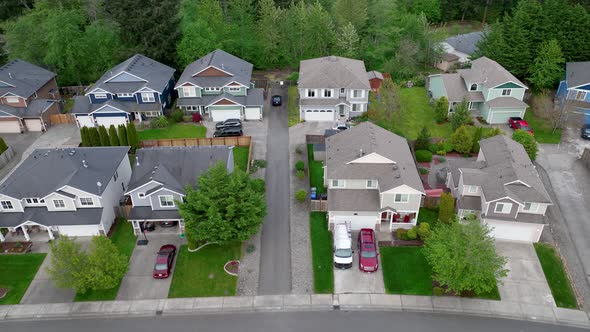 Aerial of houses built double deep off of the main suburban road.