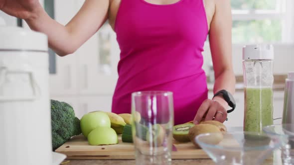 Hands of asian woman preparing smoothie in kitchen