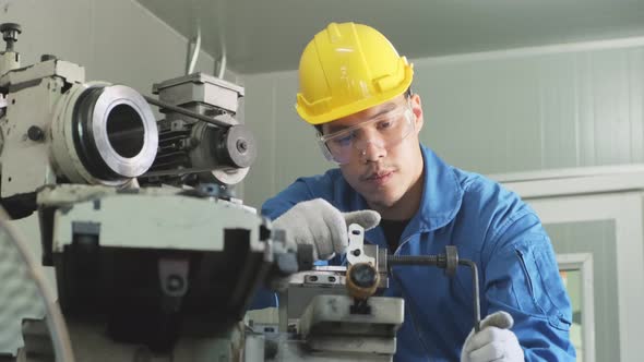 Asian mechanical technicians male workers working on milling and operating the machine in factory.