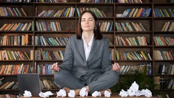 Short Haired Businesswoman Meditates Sitting in Yoga Pose