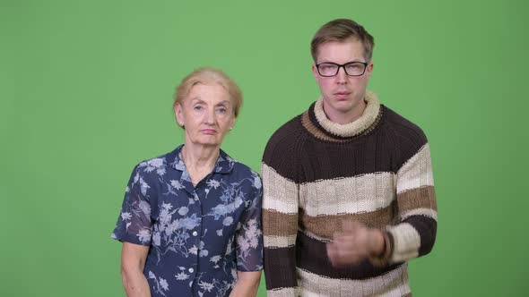 Grandmother and Grandson Looking Frustrated While Covering Face Together