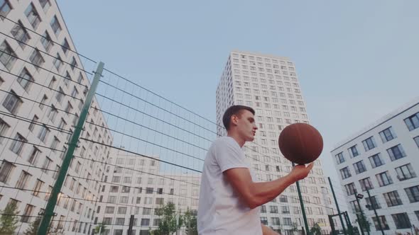 Skillful Sportsman Shows Spectacular Stunt or Trick with Ball on Basketball Play Yard or Court. Ball