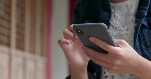 Close up of woman use of mobile phone in Chinese garden