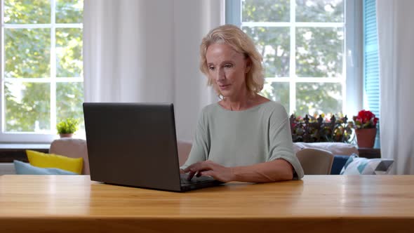 Mature Caucasian Businesswoman Working on Laptop at Home