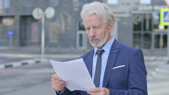 Old Businessman Reading Documents Outdoor