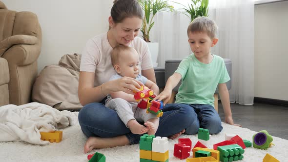 Happy Smiling Family with Children Palying on Carpet in Living Room