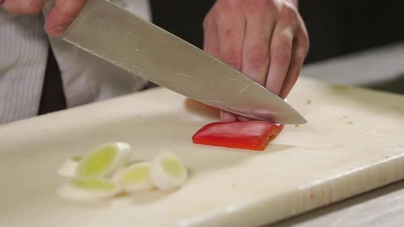 Cook Is Cutting a Red Sweet Pepper on a Wooden Board in Kitchen Table, Close-up