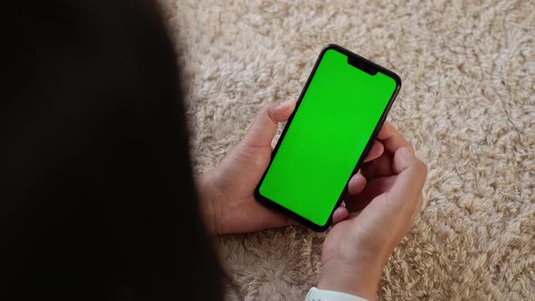 Top View Closeup View of Smartphone in Female Hands with Green Mockup Screen Chroma Key Mochup