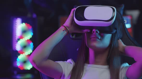 Girl Gamer Putting on a VR Glasses in Neon Lighting