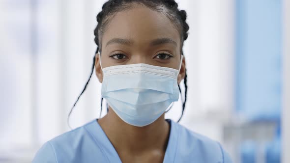 Close Up View of Woman in Medical Protective Mask Raising Head and Looking to Camera