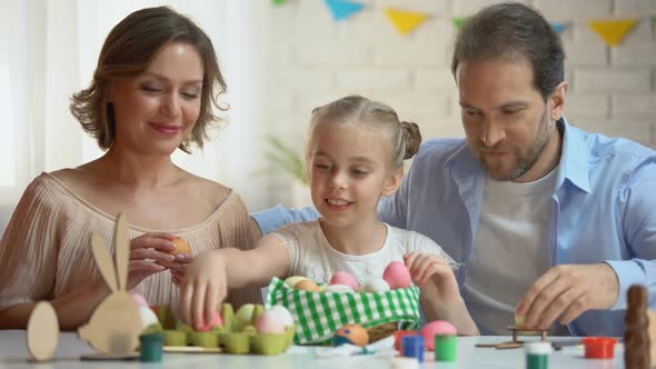 Beautiful Family Putting Dyed Easter Eggs Into Basket, Christians Traditions
