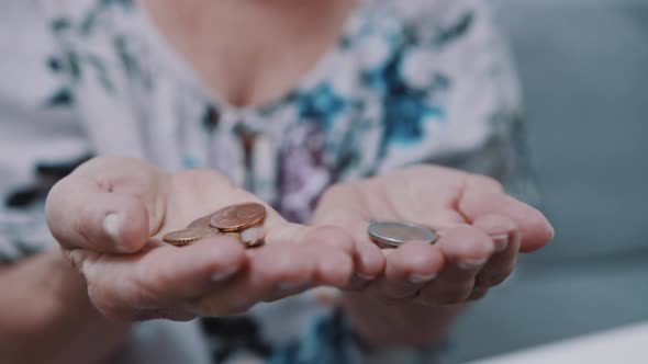 Worried Mature Woman Counting Coins. Low Pension Concept Close Up Shot on the Wrinkled Hands