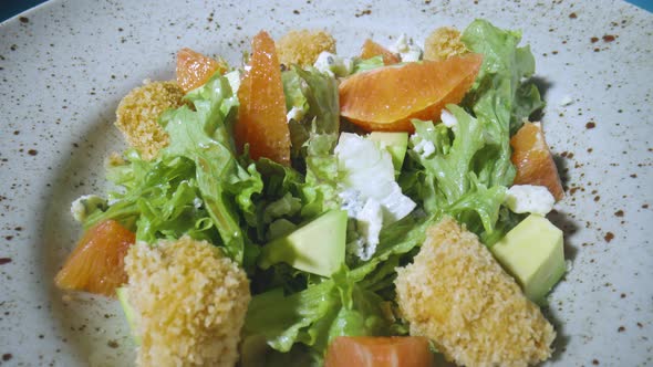 Salad with Grapefruit Green Lettuce Avocado Tuna Cheese on Gray Plate Rotating Close Up