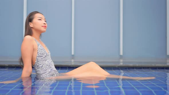 Young asian woman enjoy around outdoor swimming pool for leisure