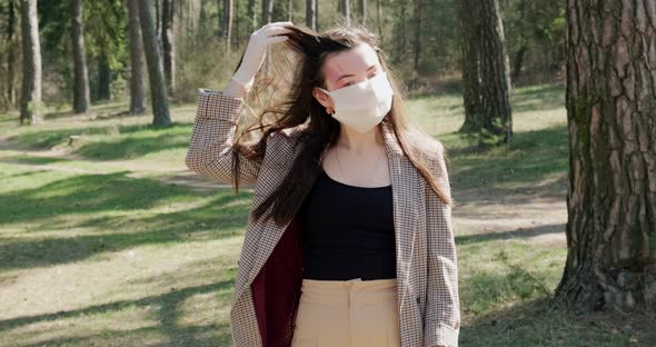 Portrait of a Young Woman Wearing Protective Mask in Coniferous Forest. Protection,covid-19